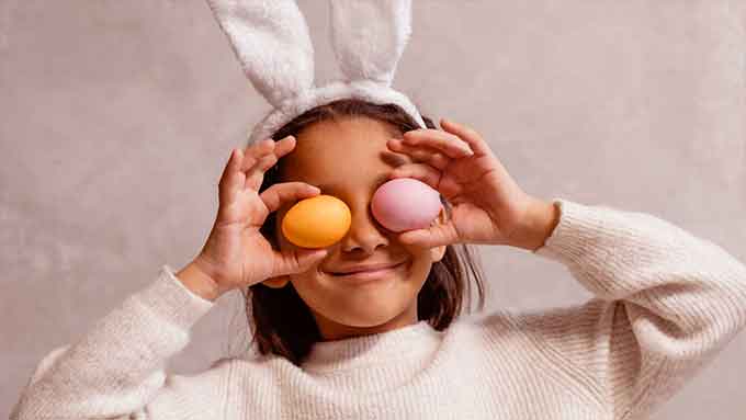 bambina vestita da coniglietto con uova